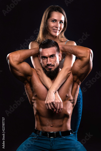 Fitness couple on a black background looking forward and smiling
