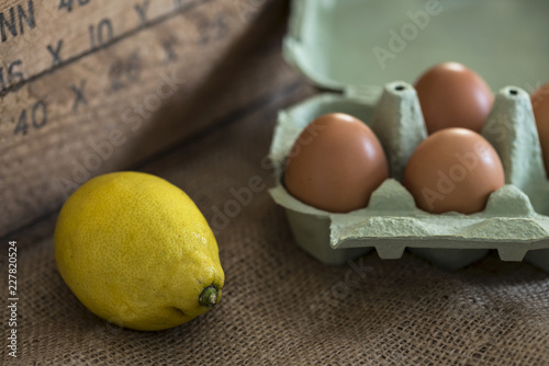 Картината върху платно Fresh ingredients -- lemon and eggs on burlap background.