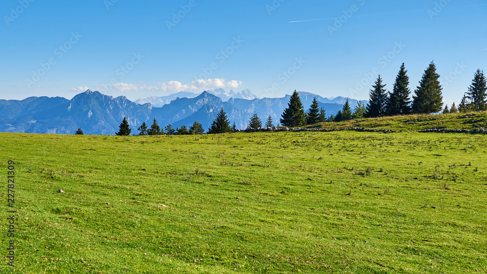 Autumn mountain valley at sunny day with blue sky, forest and green grass in Austria, Salzkammergut region.