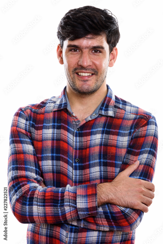 Studio shot of young happy Persian man smiling with arms crossed Studio shot of young happy Persian man smiling with arms crossed