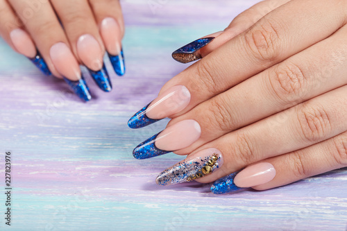 Hands with long artificial blue french manicured nails 