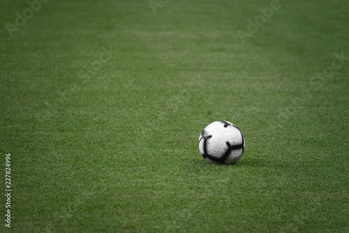 single white football ball on the green lawn of a sports stadium. football match. sports competition. ball on the field