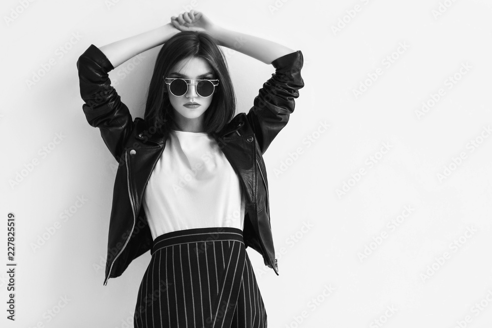 Fashion portrait of a young woman in leather jacket. Black and white ...
