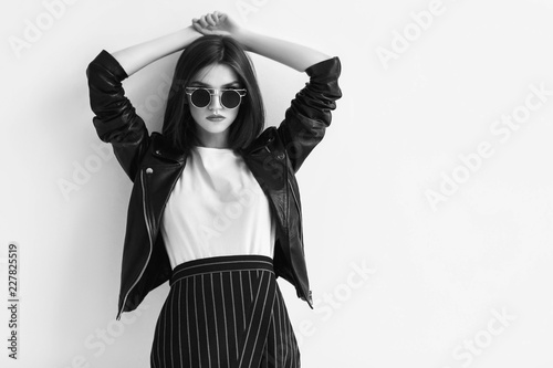 Fashion portrait of a young woman in leather jacket. Black and white image