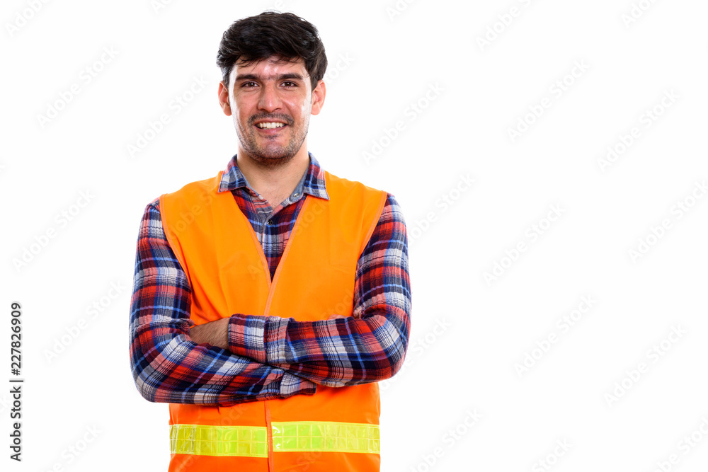 Studio shot of young happy Persian man construction worker smili Studio shot of young happy Persian man construction worker smili