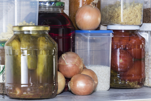 Storage shelves in pantry with homemade canned preserved fruits and vegetables photo