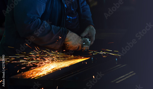 grinding machine in production polishes the metal and sparks fly out of the abrasive wheel