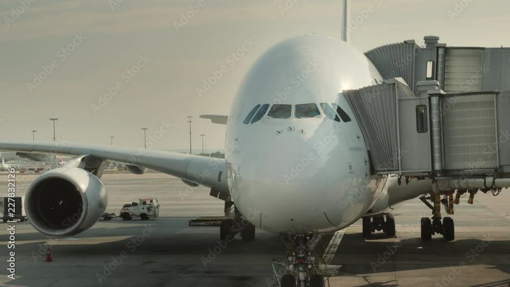Passengers board a huge airliner at the hub. Visible silhouettes of people entering the plane Passengers board a huge airliner at the hub. Visible silhouettes of people entering the plane