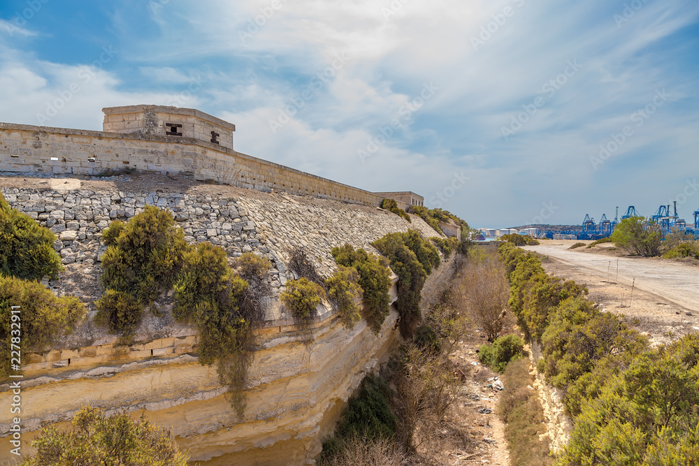 Fototapeta premium Marsaxlokk, Malta. The fortress wall and dry moat of the British Fort Delimar, 1876 - 1888