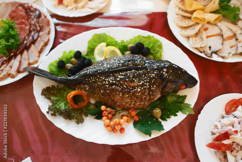 Catering service. Stuffed fish on the table Restaurant table with food on the table. Plates of food. Dinner time, lunch Catering service. Stuffed fish on the table Restaurant table with food on the table. Plates of food. Dinner time, lunch