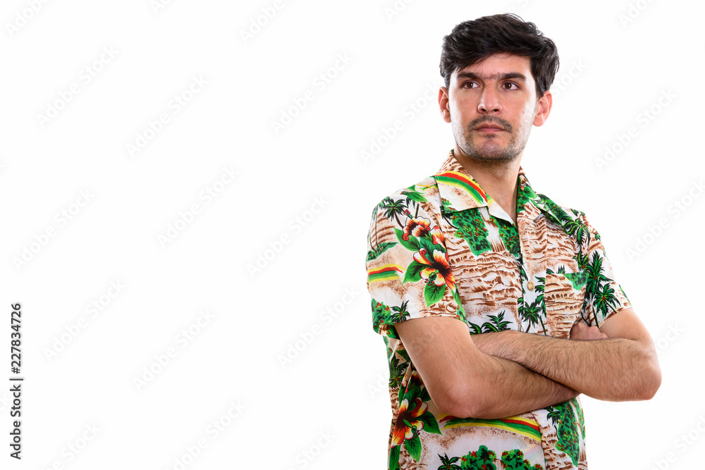 Studio shot of young Persian man thinking with arms crossed Studio shot of young Persian man thinking with arms crossed