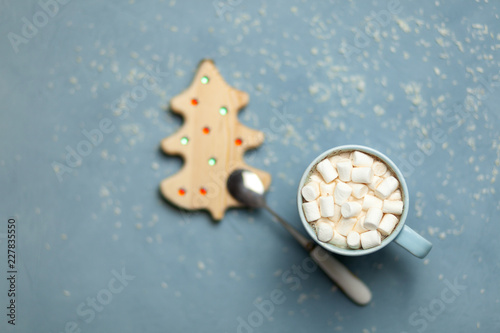 The concept of the New year and Christmas 2019. Hot cocoa with marshmallows in a blue Cup on a blue background with snow flakes. Lying next to a tree and spoon. Decor. Postcard