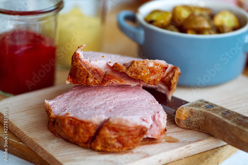 Frischer bayerischer Leberkäse und Breze aus dem Ofen mit Bratkartoffeln im Biergarten Wirtshaus zum Essen