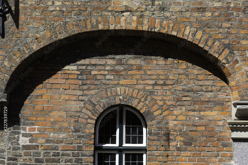 Arc shaped window on a brick wall, with arc brick shape above Arc shaped window on a brick wall, with arc brick shape above
