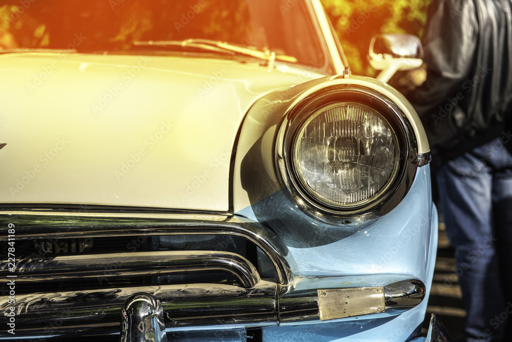 Fototapeta premium old classical car of white-blue color. macro front view. sunshine