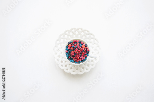 A mug filled with various berries on white background. Concept of healthy eating or diet.