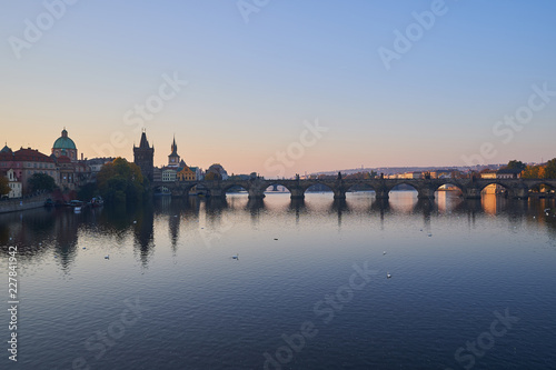 Landscape Picture of Charles bridge over Vltava river in Prague, capitol of Czech Republic in the morning during the sunrise, famous gothic style architecture in europe.
