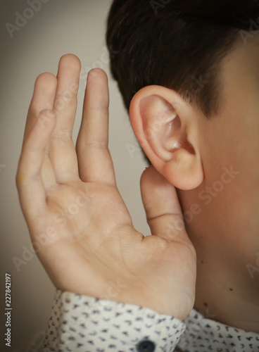 human ear and hand as a hearing listen gesture photo