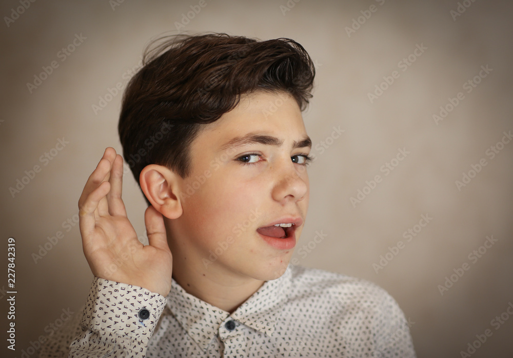 teenager boy  ear and hand as a hearing listen gesture