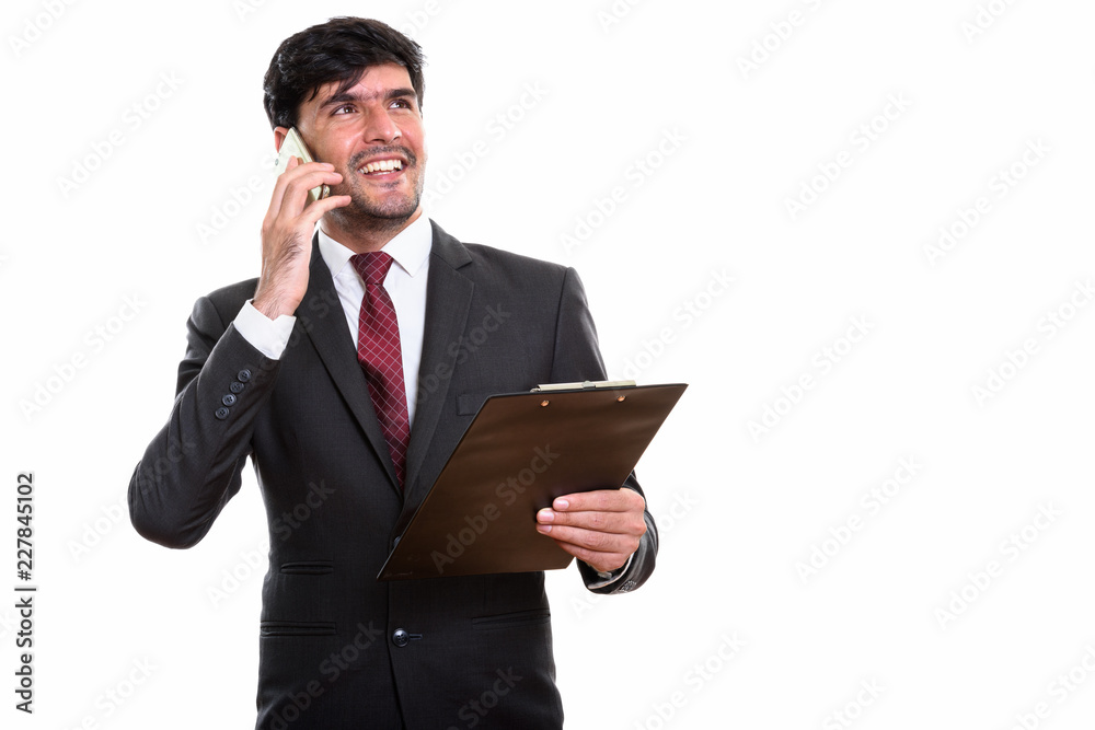 Thoughtful happy Persian businessman smiling and holding clipboa Thoughtful happy Persian businessman smiling and holding clipboa