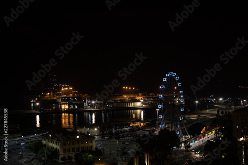 Night view of a city with the port and a ferris wheel. Malaga  Spain