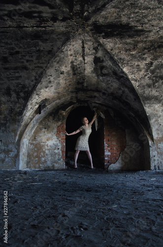 unusual wedding photo, the bride in a short seom dress in the catacombs photo