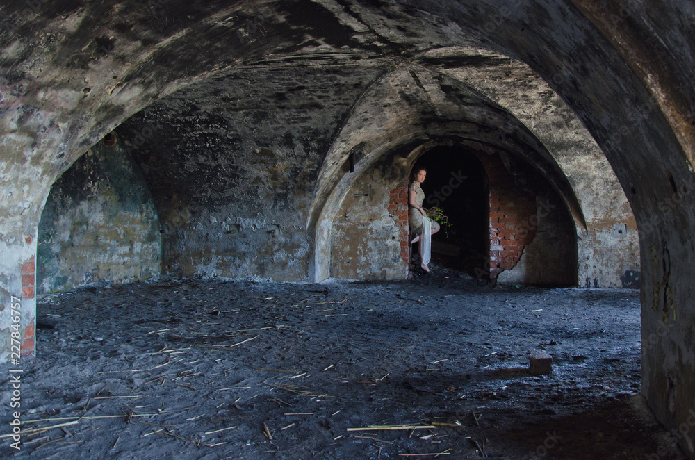 unusual wedding photo, the bride in a short seom dress in the catacombs