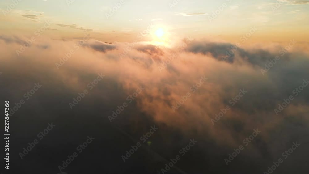 Flying through the clouds at dusk or dawn. Flying in pink clouds in the sun. Aerial view. North Caucasus Flying through the clouds at dusk or dawn. Flying in pink clouds in the sun. Aerial view. North Caucasus