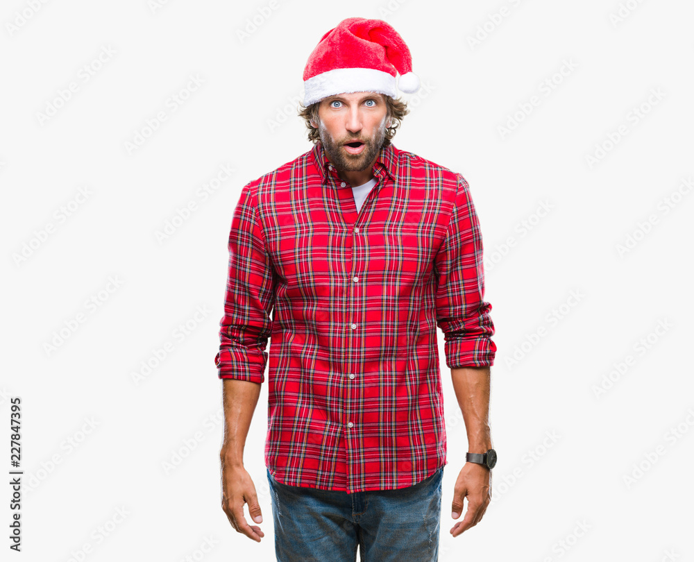 Handsome hispanic man model wearing santa claus christmas over isolated background afraid and shocked with surprise expression, fear and excited face. Handsome hispanic man model wearing santa claus christmas over isolated background afraid and shocked with surprise expression, fear and excited face.