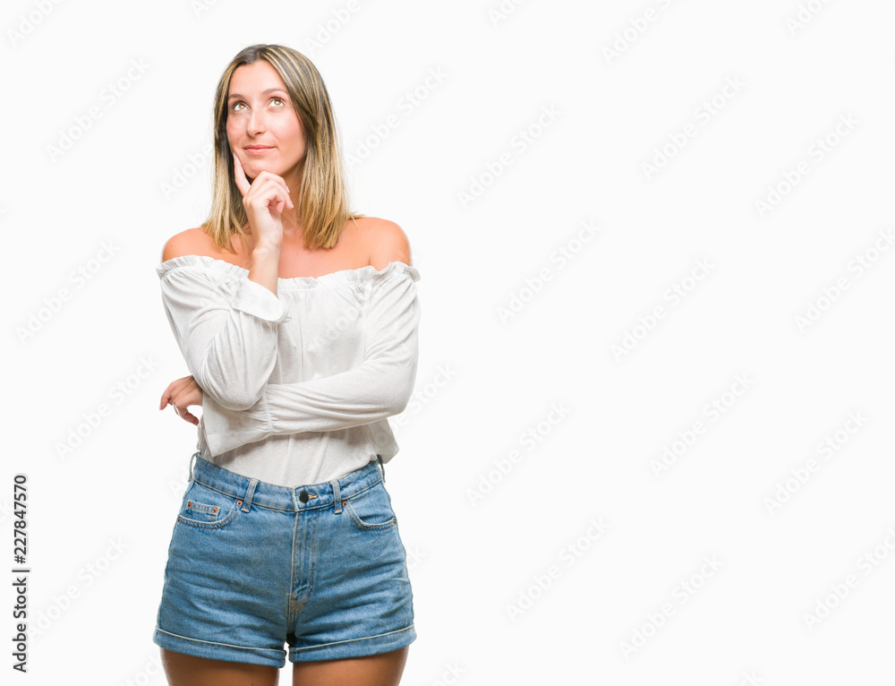 Young beautiful woman over isolated background with hand on chin thinking about question, pensive expression. Smiling with thoughtful face. Doubt concept. Young beautiful woman over isolated background with hand on chin thinking about question, pensive expression. Smiling with thoughtful face. Doubt concept.