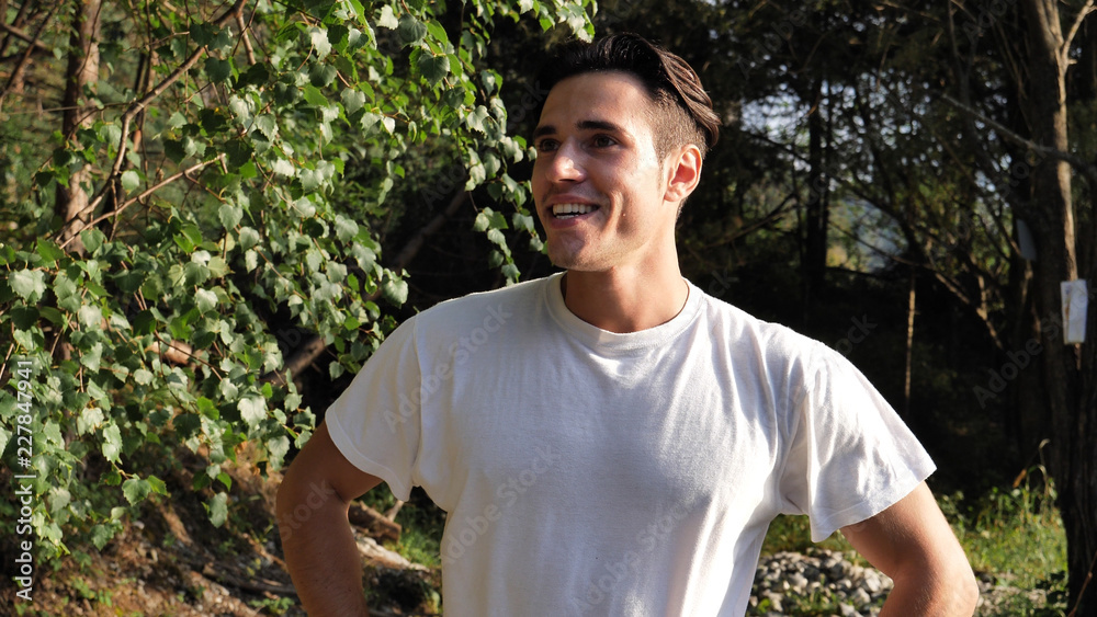 Handsome athletic young man in nature smiling, in a sunny, peaceful day, looking at camera Handsome athletic young man in nature smiling, in a sunny, peaceful day, looking at camera
