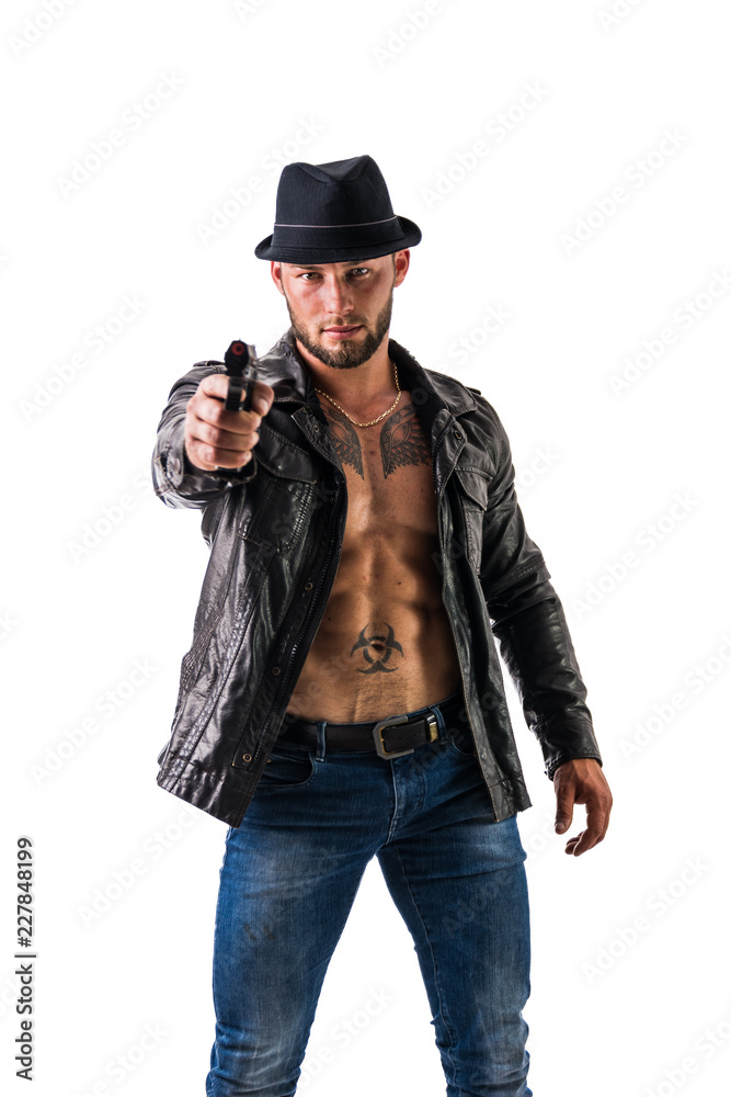 Handsome man wearing leather jacket on naked muscular torso pointing gun to camera, isolated on white background, looking straight. Handsome man wearing leather jacket on naked muscular torso pointing gun to camera, isolated on white background, looking straight.