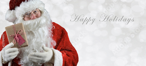 Banner sized inage with Santa Claus holding a present photo