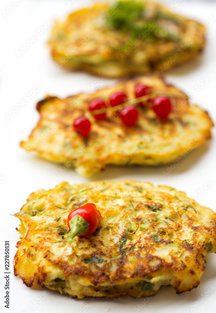 Vegetable zucchini pancakes, served with fresh herbs and garlic yogurt sauce, vegetarian fritters Vegetable zucchini pancakes, served with fresh herbs and garlic yogurt sauce, vegetarian fritters