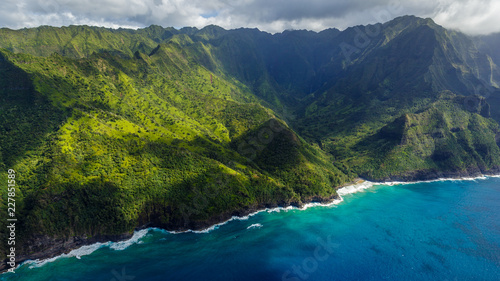Aerial view on Na Pali Coast with Hanakapiai Falls and Hanakapiai Beach, Kauai, Hawaii. Kalalau trail is visible if zoomed in. Aerial shot from a helicopter.