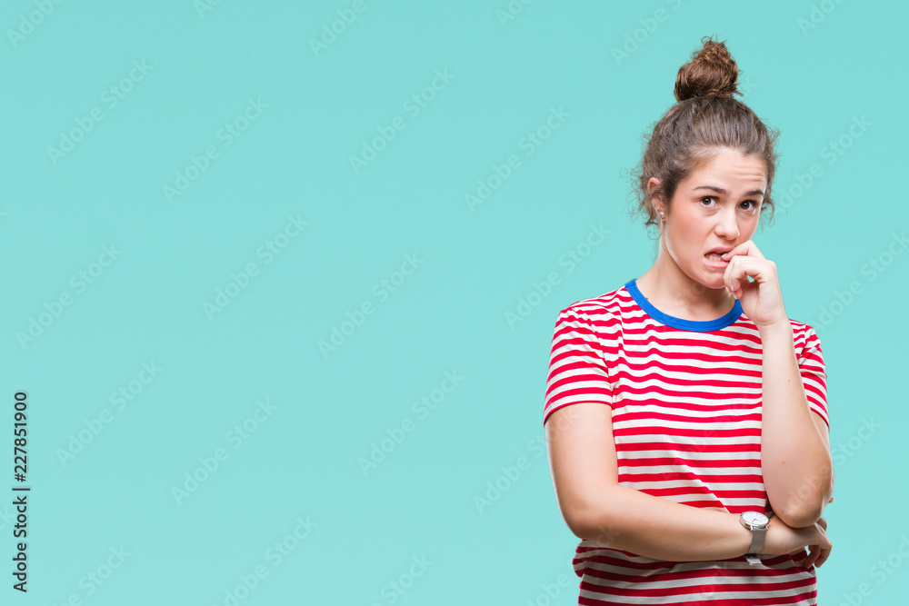 Beautiful brunette curly hair young girl wearing casual look over isolated background looking stressed and nervous with hands on mouth biting nails. Anxiety problem.