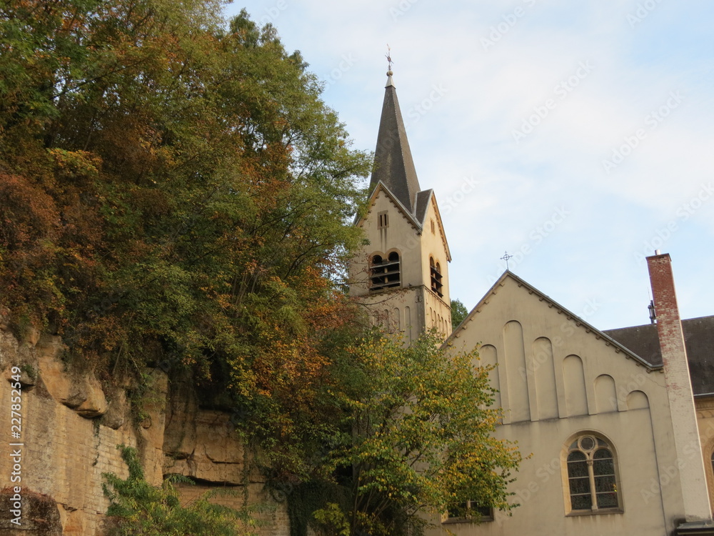Old church in Luxembourg lower city, next to natural rock wall, in autumn
