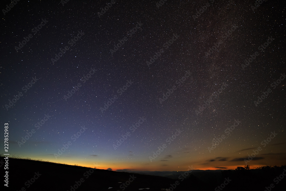 The bright stars of the Milky Way in the night sky above the horizon before the dawn.