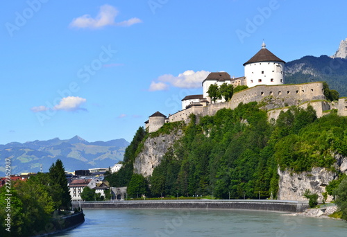 Castle on a rock above river with blues sky in the background