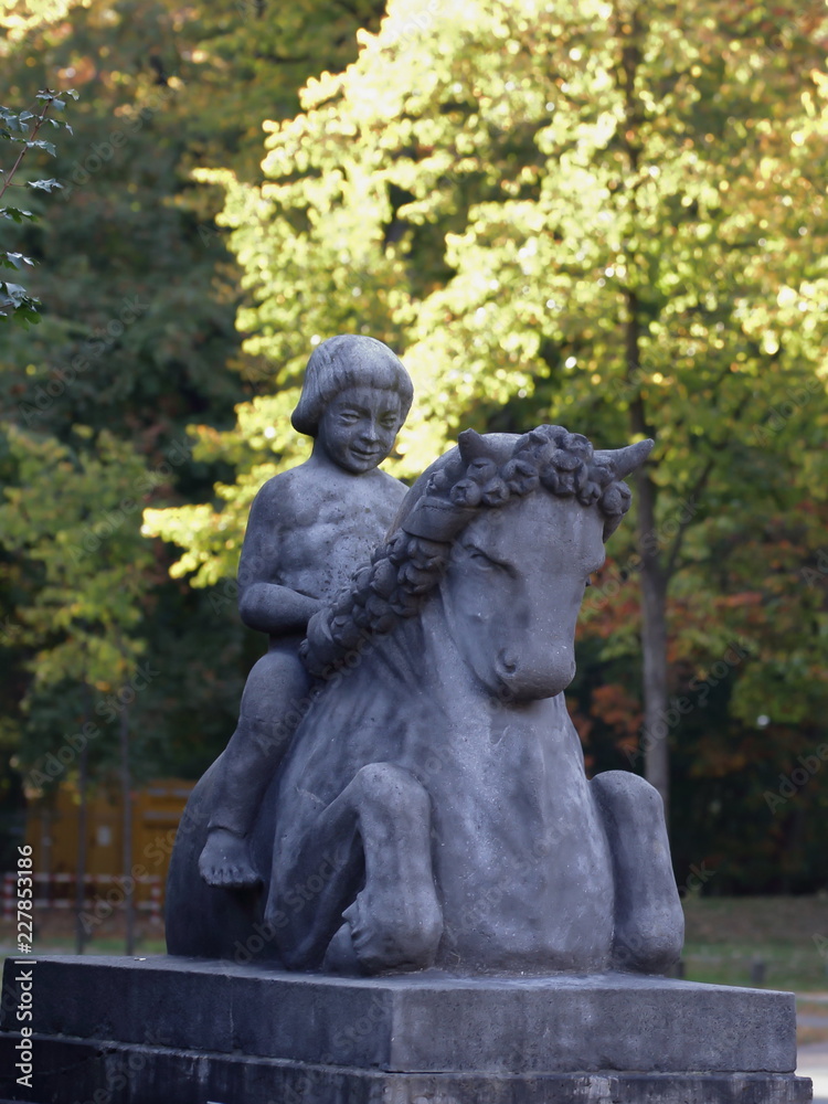 Stone figure, weathered, child on horse, bridge town Hamm in Germany