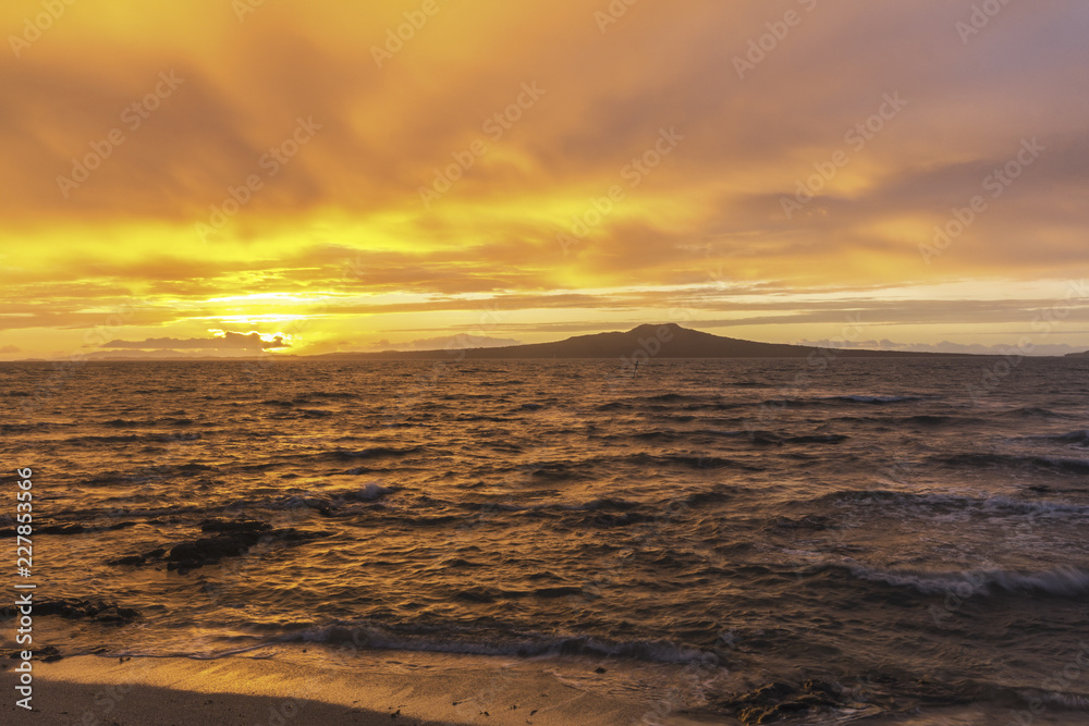Landscape Scenery during Sunrise Time at Takapuna Beach, Auckland New Zealand; View to Rangitoto Island; Rough Seas