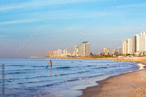Young man surf in the shore of Tel Aviv Israel, at sunset © Roni