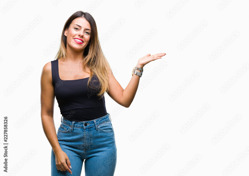 Young beautiful woman over isolated background smiling cheerful presenting and pointing with palm of hand looking at the camera.