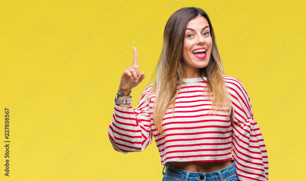Young beautiful woman casual stripes winter sweater over isolated background pointing finger up with successful idea. Exited and happy. Number one. Young beautiful woman casual stripes winter sweater over isolated background pointing finger up with successful idea. Exited and happy. Number one.