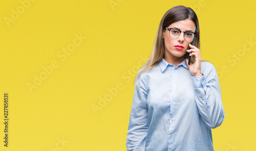 Young beautiful business woman speaking calling using smartphone over isolated background with a confident expression on smart face thinking serious