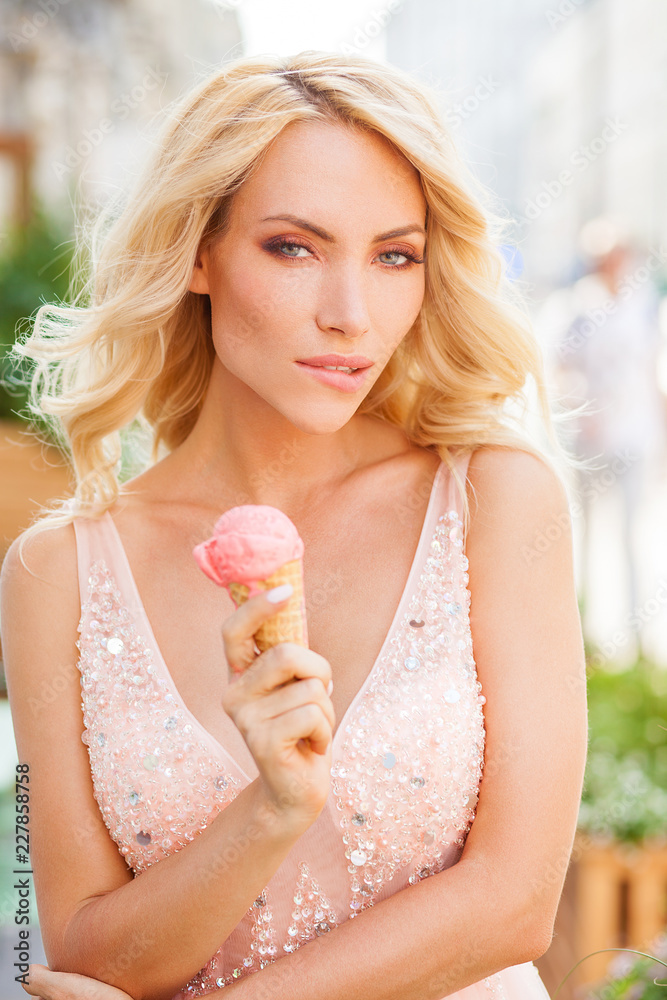 Portrait of beautiful sexy young blonde woman with long curly hair eating delicious ice cream Portrait of beautiful sexy young blonde woman with long curly hair eating delicious ice cream