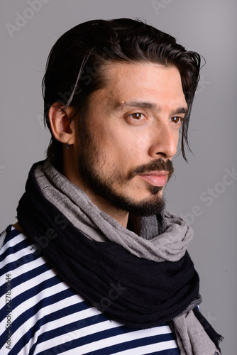 Face of handsome man thinking against gray background