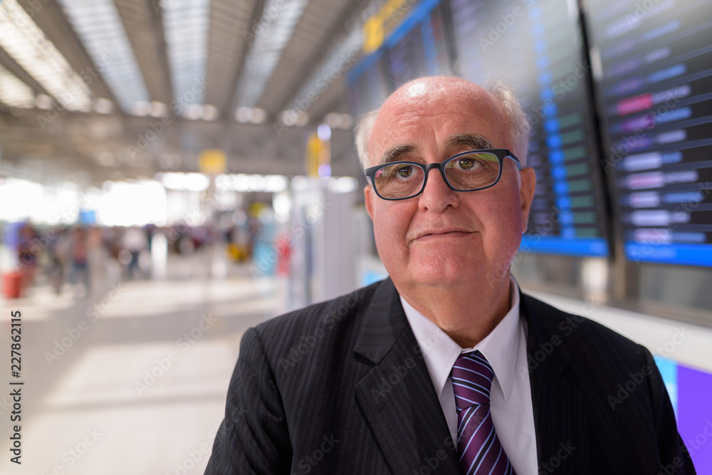 Overweight senior businessman lounging around the airport of Ban Overweight senior businessman lounging around the airport of Ban