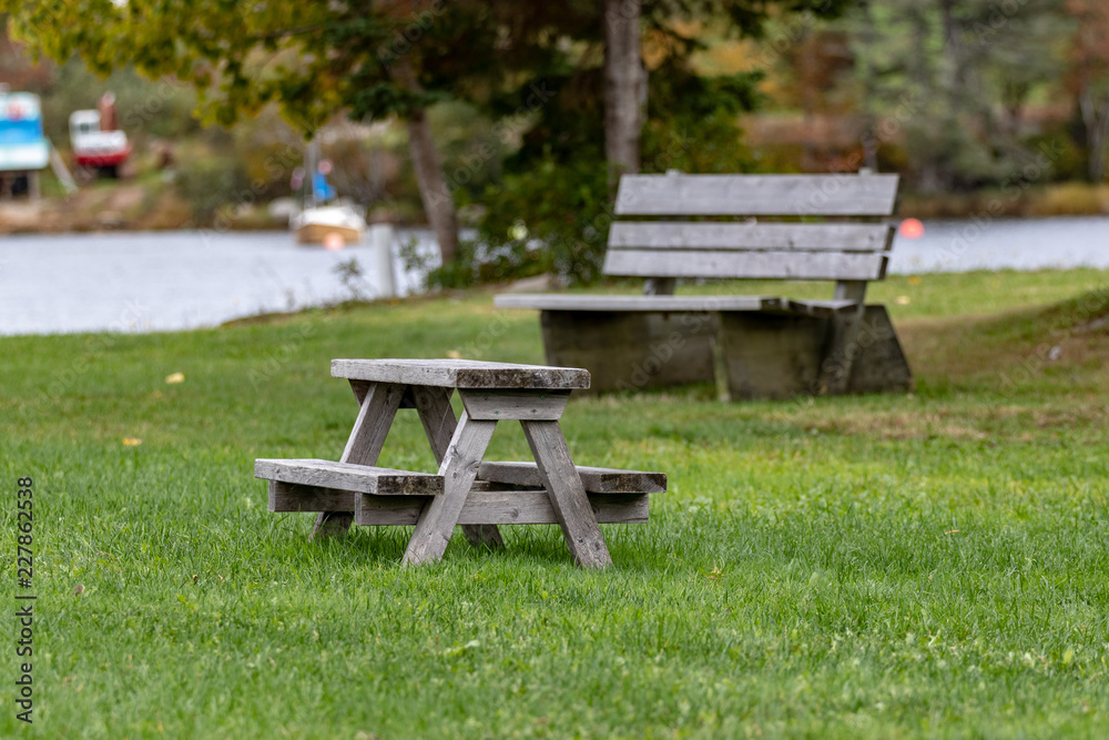 wooden bench in the park with childs' picnic table in foreground wooden bench in the park with childs' picnic table in foreground