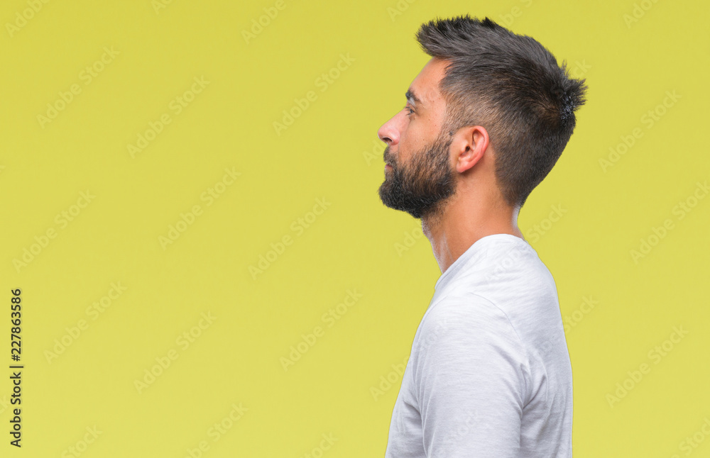 Adult hispanic man over isolated background looking to side, relax profile pose with natural face with confident smile.
